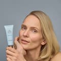 Donna tiene in mano e mostra day cream